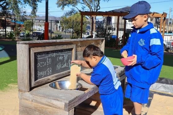A group of boys playing in mud kitchen sensory playground