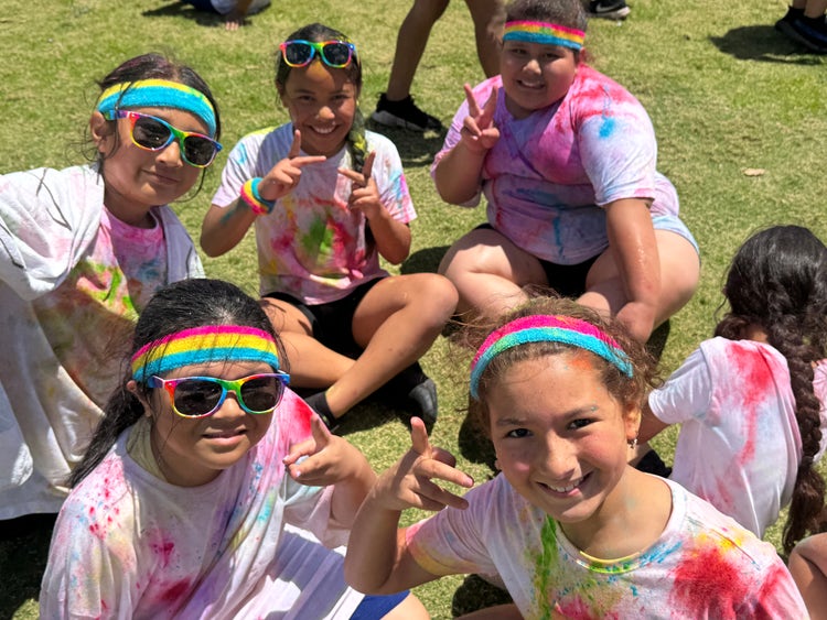 Students smiling at the camera after running in a Colour Run